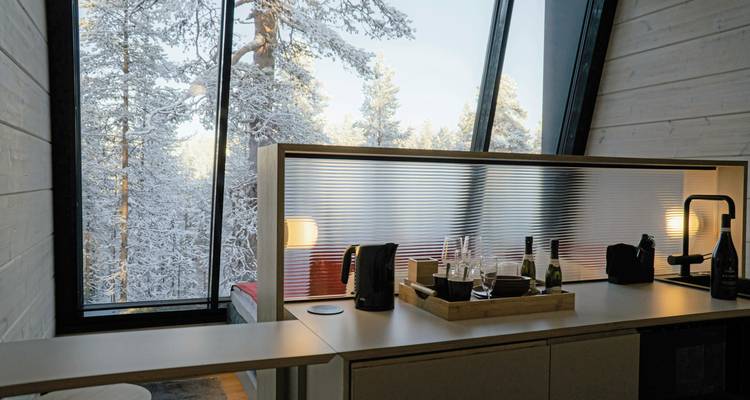 Modernes Interieur mit großen Fenstern mit Blick auf verschneite Landschaft.