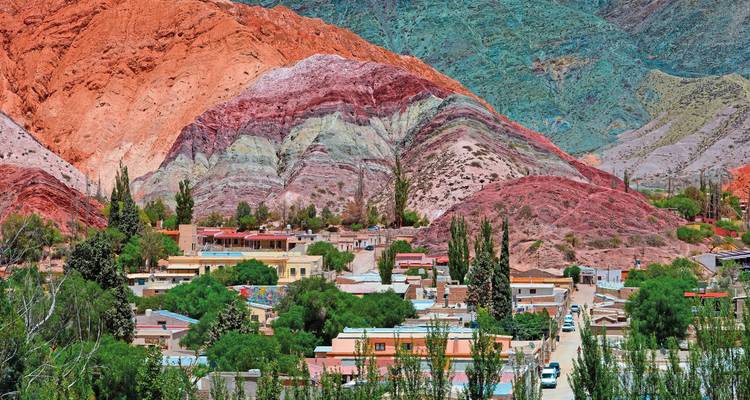 Formations géologiques colorées entourant un village.