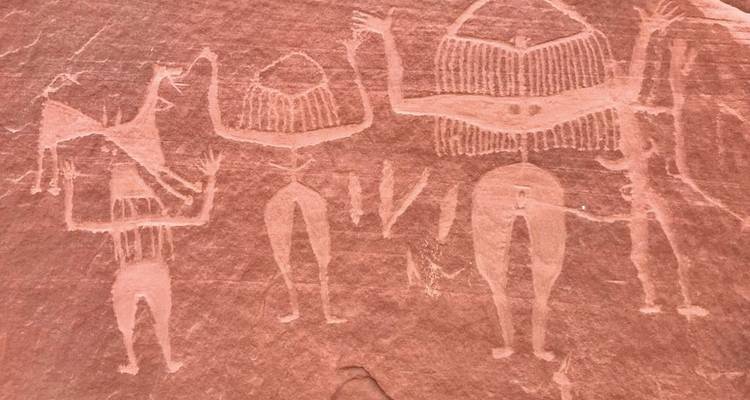Ancient petroglyphs carved into reddish-brown rock.