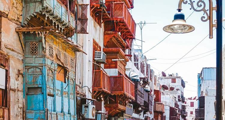 Old buildings with ornate wooden balconies in a row.