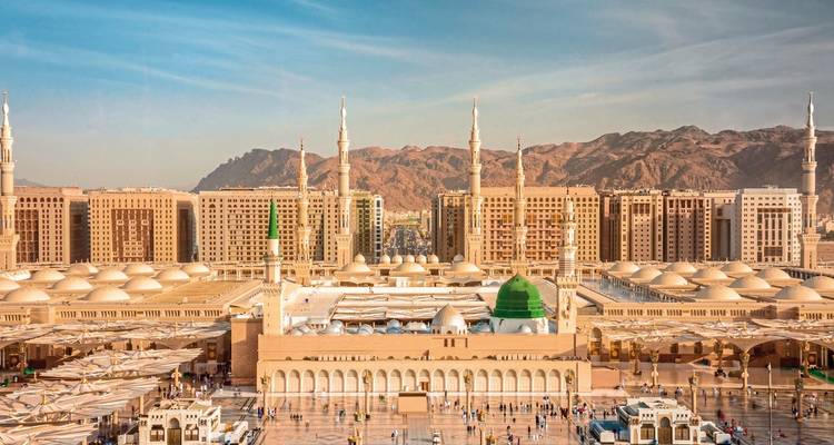 Historische Moschee mit Bergen im Hintergrund.