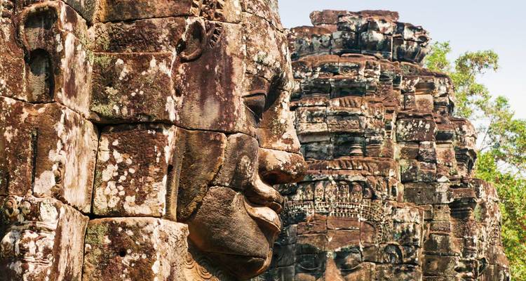 Primer plano de rostros de piedra antiguos en un complejo de templos.