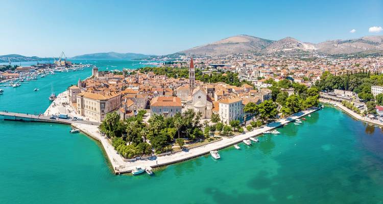 Vue panoramique d'une ville côtière avec une église au centre.