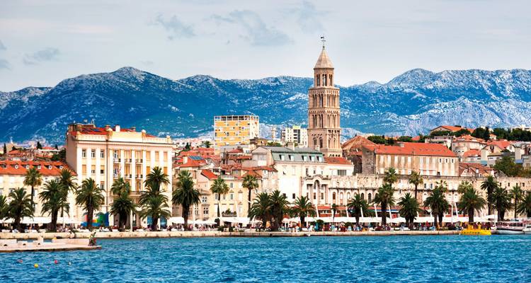 Horizon urbain au bord de l'eau avec des montagnes en arrière-plan.