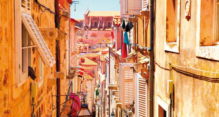 Rue étroite avec des bâtiments colorés et des toits rouges.