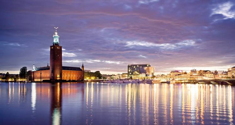 Illuminated building by the water during twilight.