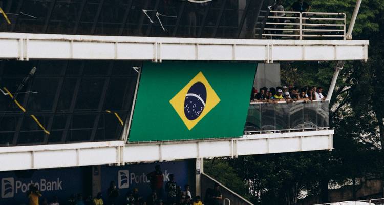 Zuschauer, die von einem Gebäude mit einer brasilianischen Flagge aus zuschauen.