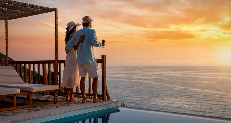Stel geniet van zonsondergangsuitzicht vanaf een terras.