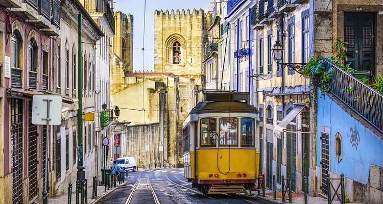Tramway jaune dans une rue étroite avec des bâtiments historiques