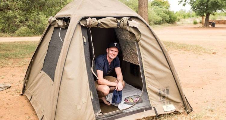 Personne assise devant une tente de camping