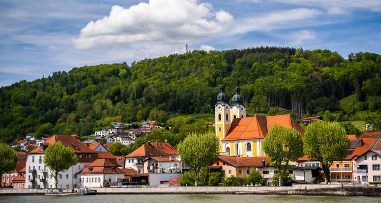 Picturesque view of Passau with a historic church and trees.