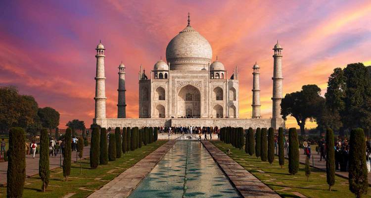 Taj Mahal avec reflet dans le bassin au premier plan au coucher du soleil.