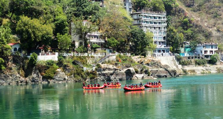 Activité de rafting en rivière avec plusieurs radeaux dans un environnement pittoresque.