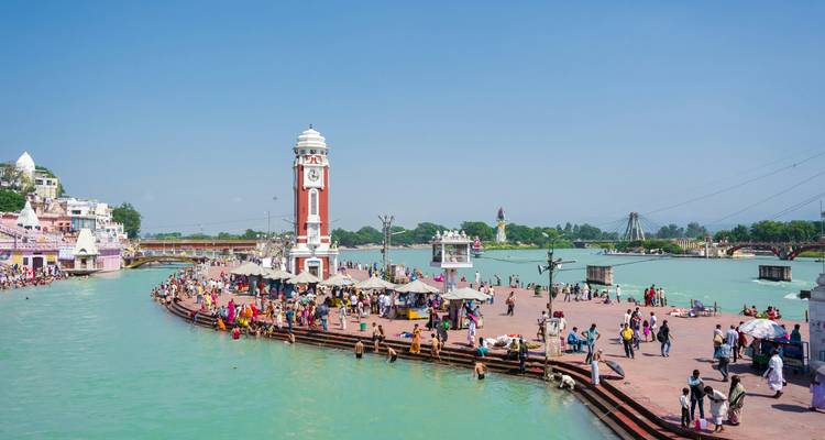 Rive bondée avec une tour d'horloge à Haridwar.
