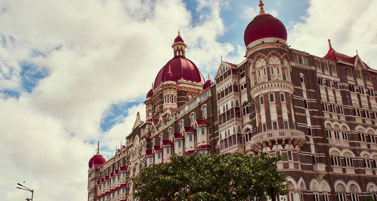 Un bâtiment d'hôtel historique avec des dômes rouges sous un ciel nuageux.