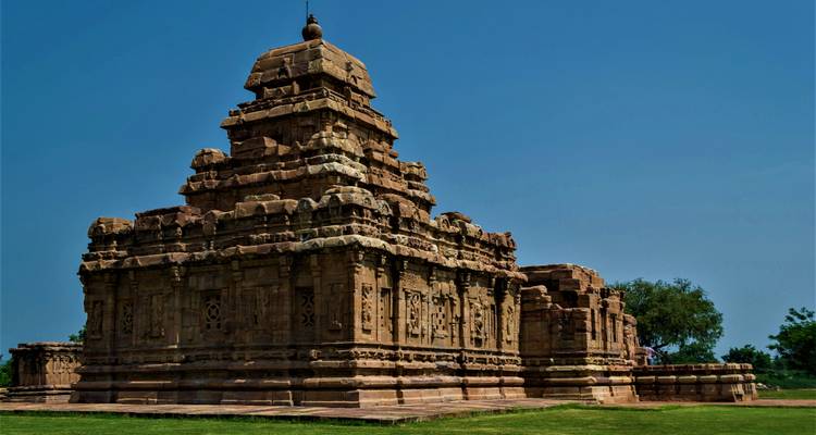 Un temple historique avec des sculptures complexes sur fond de ciel bleu.