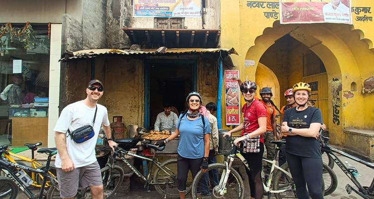 A group of cyclists taking a break next to a food stall.
