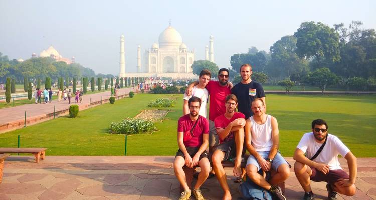A group of friends posing in front of the Taj Mahal.