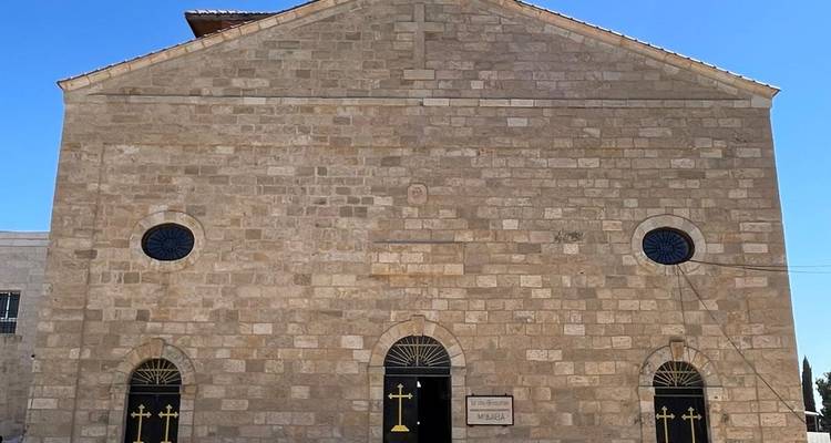 Vue de face d'un bâtiment d'église avec trois portes et fenêtres.