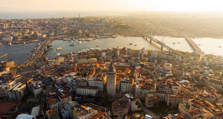 Hoog luchtfoto van Istanbul met de Galata Toren, de Gouden Hoorn en bruggen bij een mistige zonsondergang.