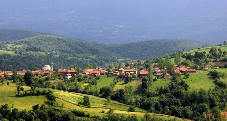 Vista panorámica de un pueblo enclavado entre colinas verdes.