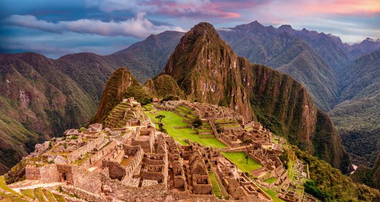 Panoramic view of Machu Picchu with clear skies at sunset.