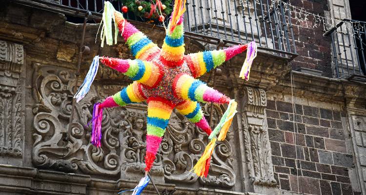 Colorful star-shaped pinata hanging against a historic building.