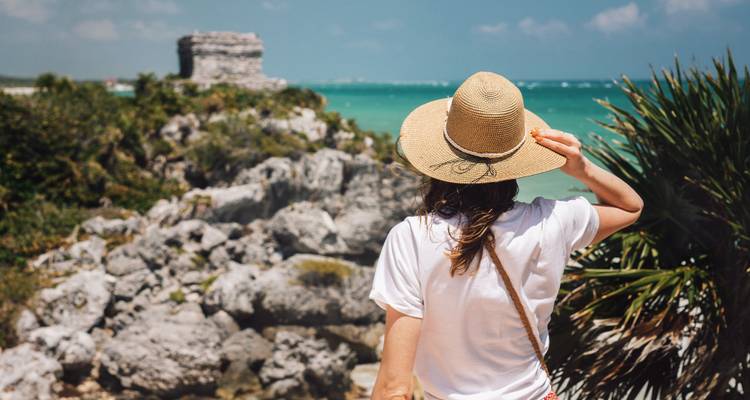 Person looking at the ocean and Mayan ruins.