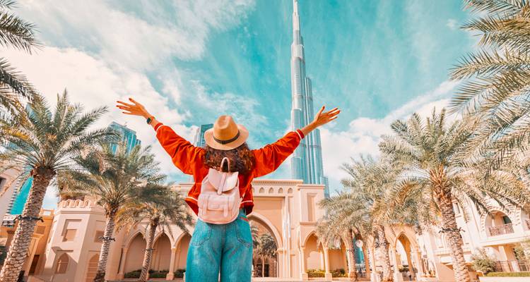 Personne les bras levés devant le Burj Khalifa.