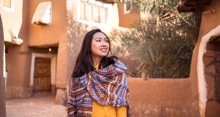 Vrouw in traditionele omgeving van historische gebouwen.
