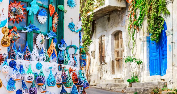Hand-made colorful ceramics displayed on a wall in a Mediterranean street.