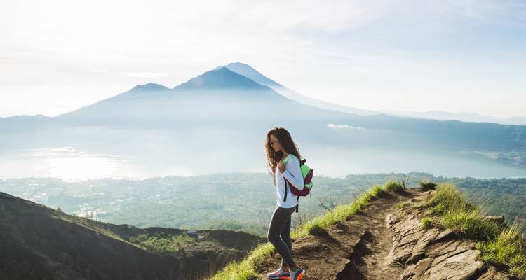 Person hiking on a trail with a mountain view.