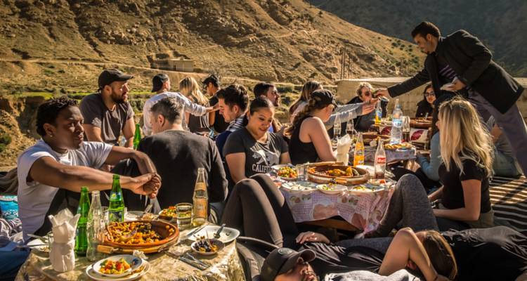 Un groupe de personnes profitant d'un repas en plein air dans un cadre montagnard.