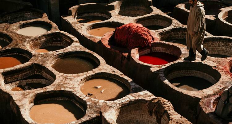Fosses de tannage traditionnelles en cuir avec liquides colorés dans de grandes cuves.