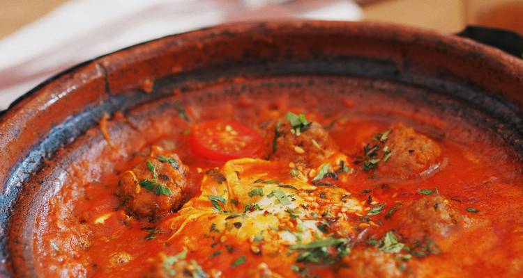 Gros plan d'un plat de tajine marocain aux couleurs et textures éclatantes.