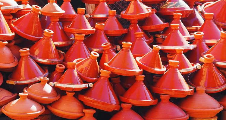 Pile de tajines marocains traditionnels exposés dans un marché.