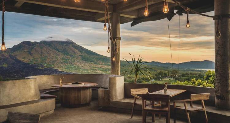 Vue panoramique depuis un café avec des montagnes en arrière-plan.
