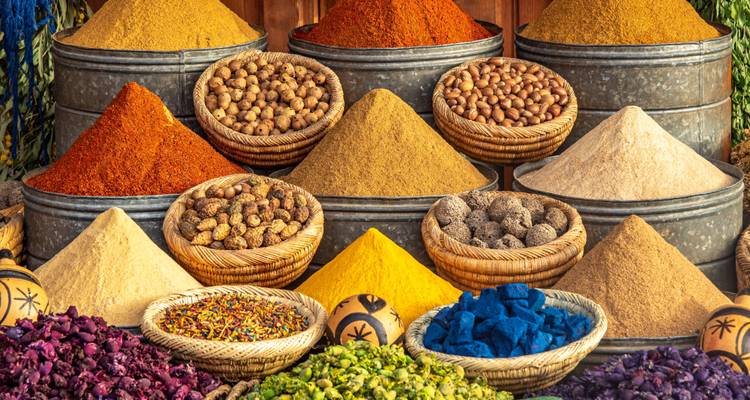 Lebhafte Präsentation von Gewürzen auf dem Markt mit Körben und Behältern.