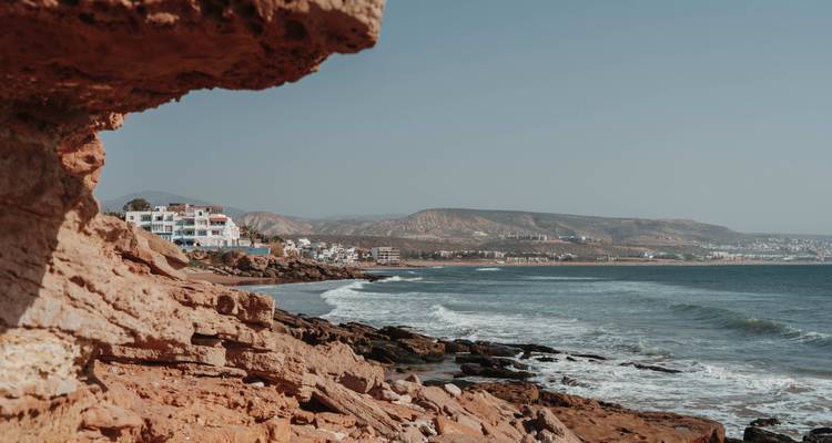Rugged coastal landscape with ocean waves and rocky cliffs.