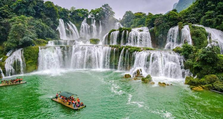 Cascade avec bateaux and touristes dans un cadre pittoresque.