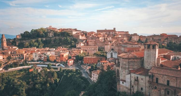 View of a historic city with a large cathedral and red roofs.