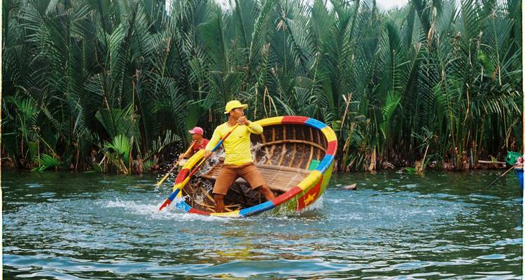 Tourists boating in a lush green area with reeds and trees.