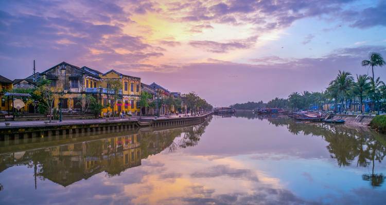 Scenic view of a canal with reflection of colorful buildings and sky.