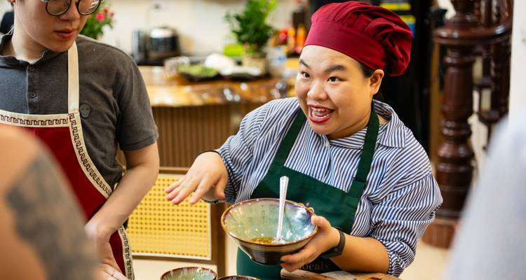 Participants in a cooking class discussing a dish preparation.