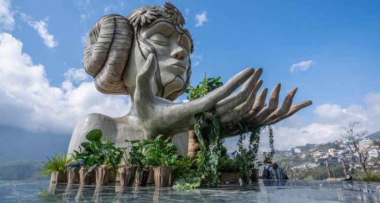 Une grande sculpture artistique avec un environnement luxuriant.