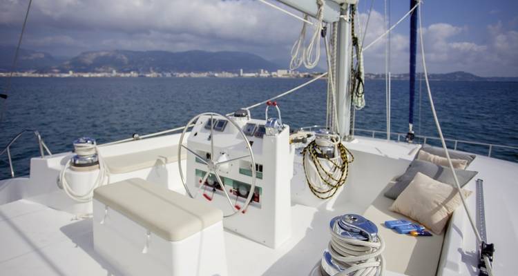 Sailing catamaran deck with ocean background.