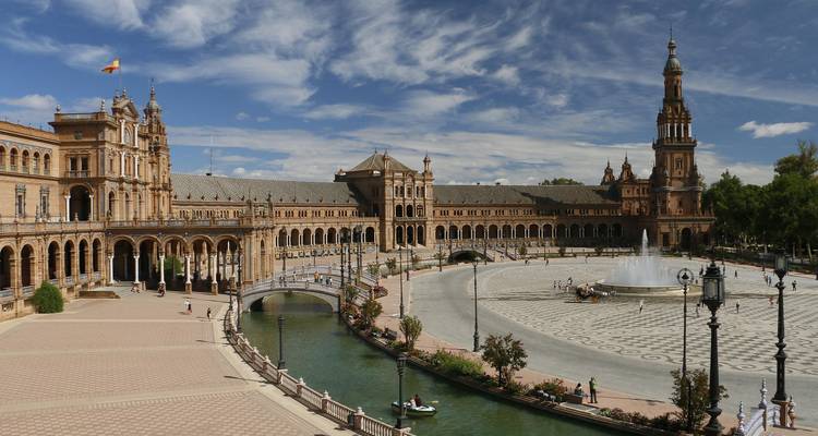 Place avec une grande fontaine et des bâtiments historiques.