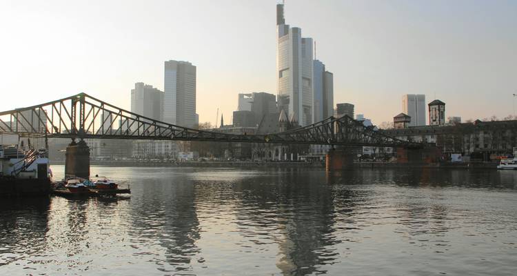 Rivière avec un pont et horizon urbain en arrière-plan.