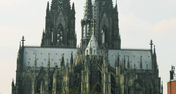 Cathédrale gothique avec de hautes flèches contre un ciel lumineux.