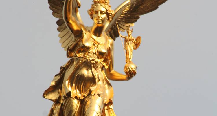 Golden angel statue holding a small angel statue.